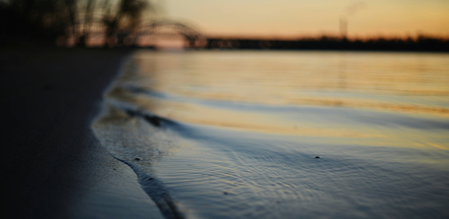 Gentle waves meeting the shoreline at dusk, symbolising transition and liminal space