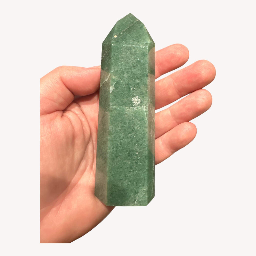 
                  
                    Aventurine crystal generator held in hand, revealing its backside. The smooth surface and cool touch highlight the craftsmanship and the crystal's natural variations, perfect for meditation and positive vibes.
                  
                