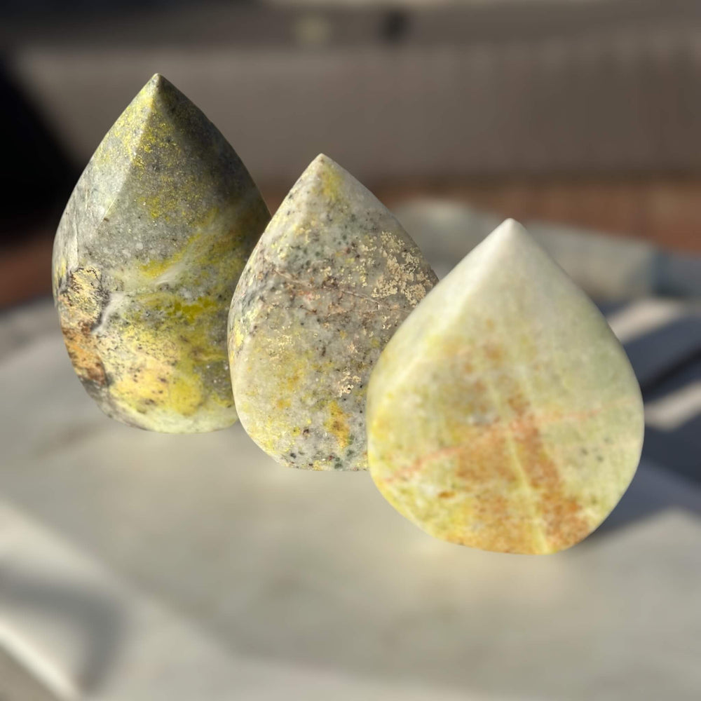 Three Lemon Serpentine Crystal Flames in varying sizes. Sizes include 12.5cm, 10.5cm, and 9.5cm. Each crystal flame is uniquely shaped and carries the energy of Lemon Serpentine