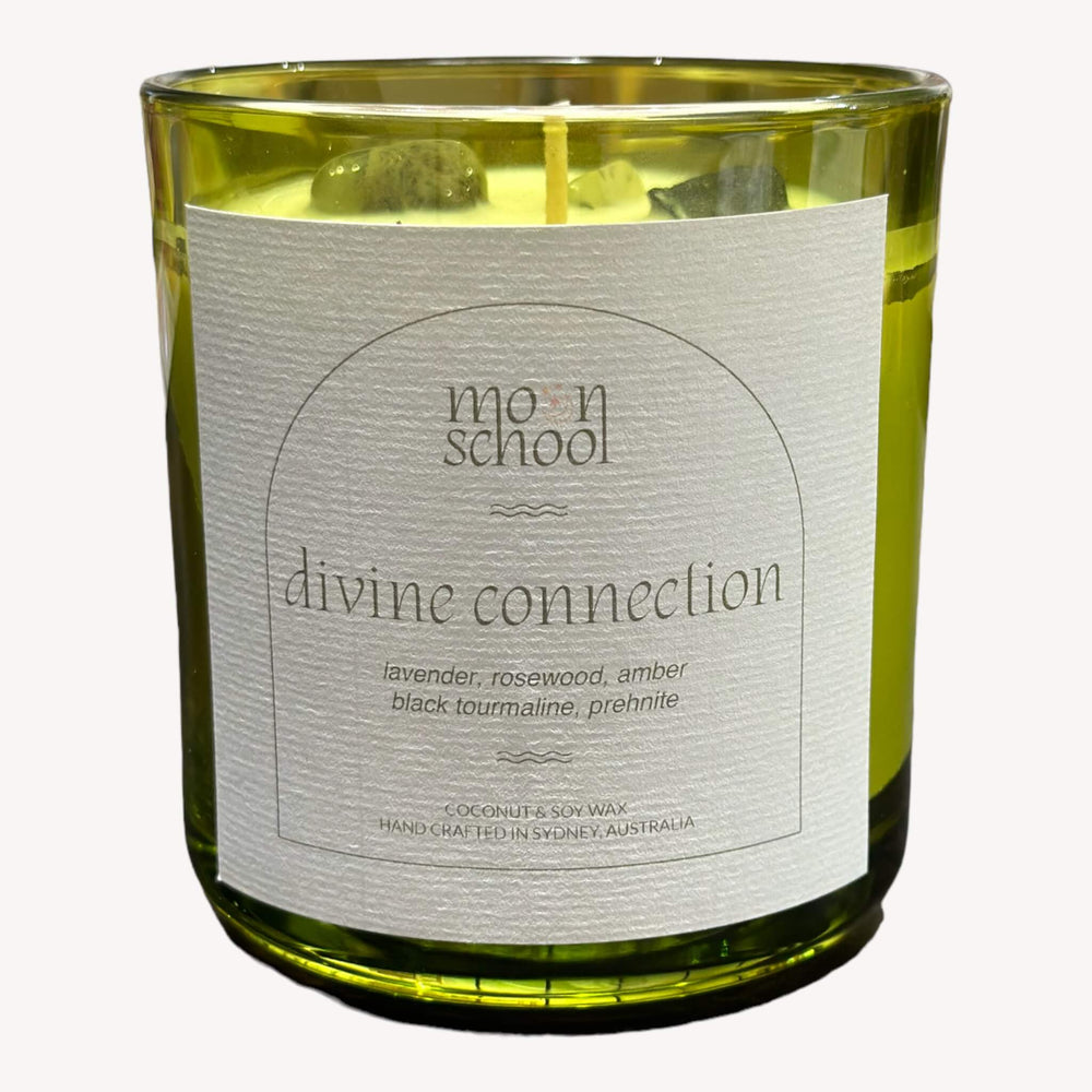 
                  
                    Front view of Moon School's DIVINE CONNECTION Crystal Candle in the large size (400mls). The retro green glass jar houses a blend of premium coconut and soy wax, infused with lavender, rosewood, and amber scents for a transformative experience.
                  
                