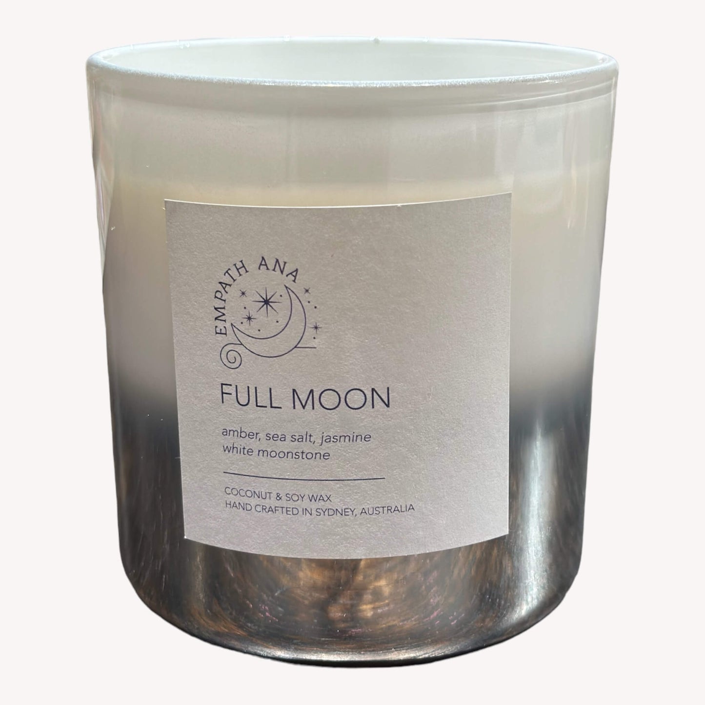 Front view of Empath Ana's Full Moon Crystal Candle in the Large size (400mls). Crafted on the day of a Full Moon, this candle is topped with ethereal White/Rainbow Moonstone and infused with Amber, Sea Salt, and Jasmine. A celestial blend for reflective moments and joyous celebrations.