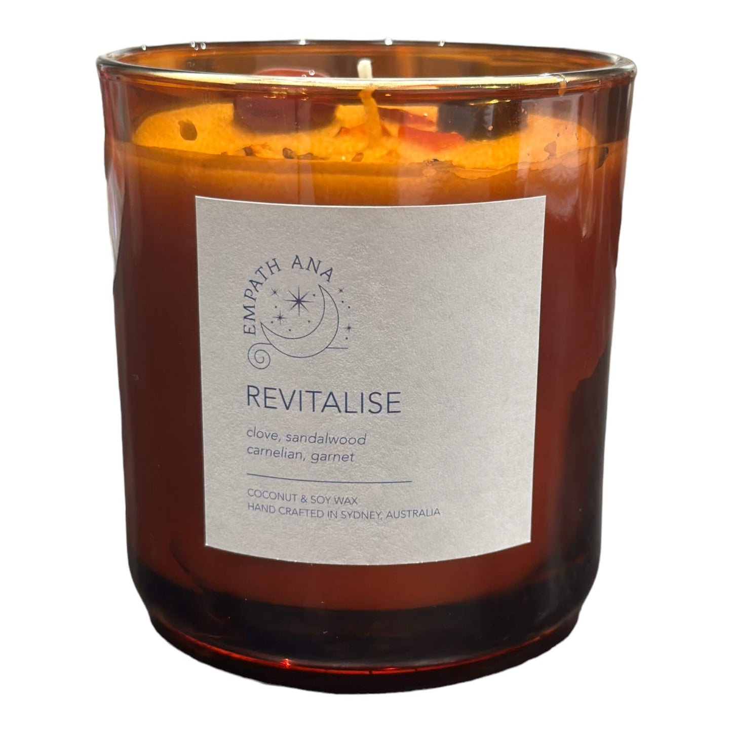 
                  
                    Large Revitalise Crystal Candle - Infused with Warm Clove and Sandalwood Scents, Enhanced with Carnelian and Garnet Crystals.
                  
                