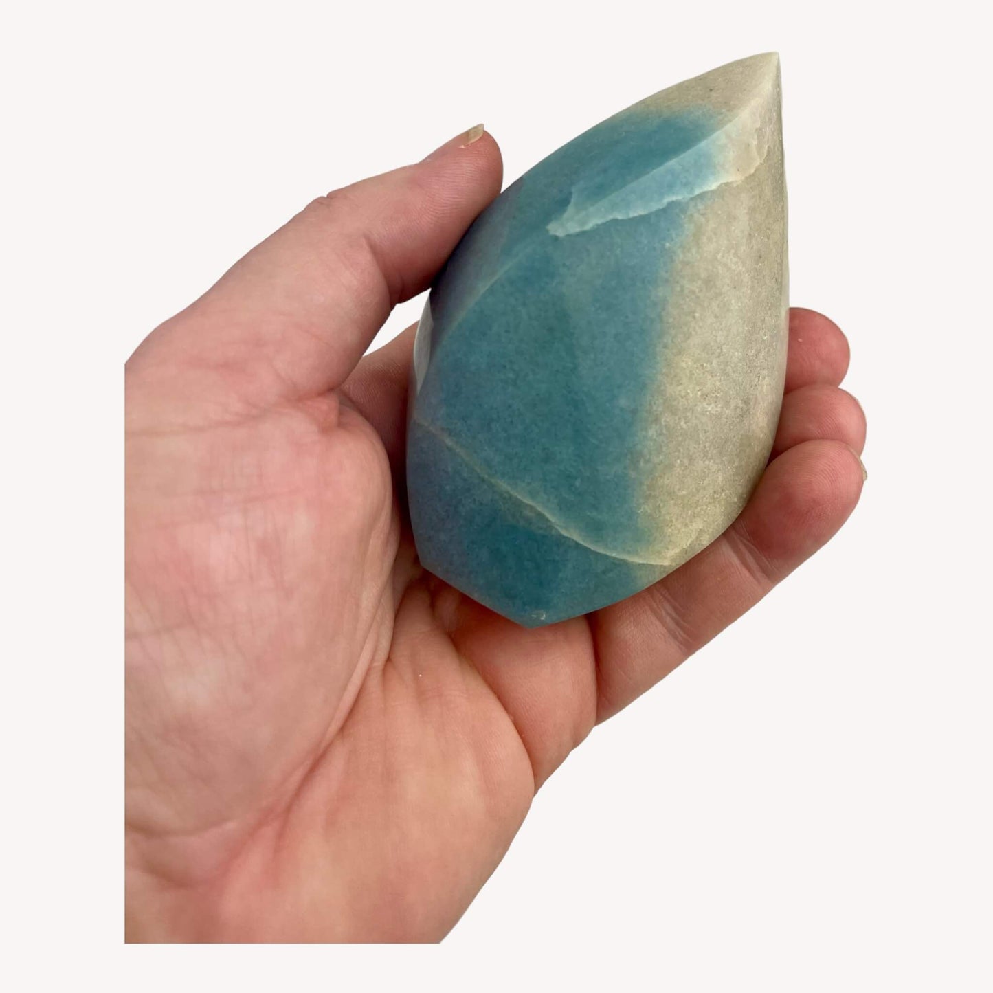 The small Trolleite Crystal Flame cradled in hand, a tiny wonder with cosmic secrets.