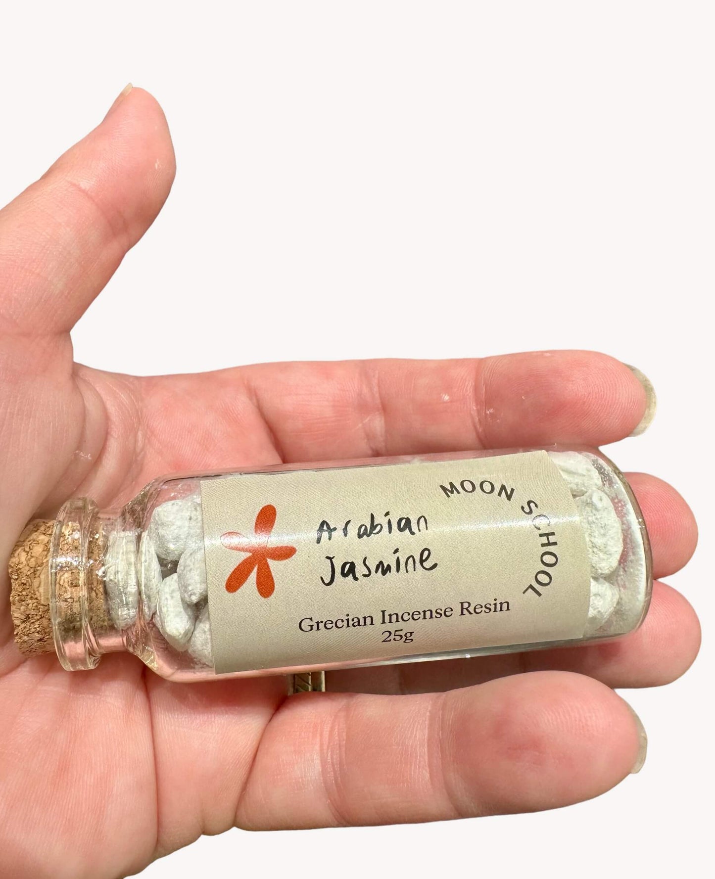 Bottle of Grecian Arabian Jasmine Incense Resin held in hand. Experience the luxurious allure of A Grade Jasmine, meticulously handcrafted in the sun-soaked landscapes of Greece. Elevate your space with the delicate floral embrace of Arabian Jasmine.