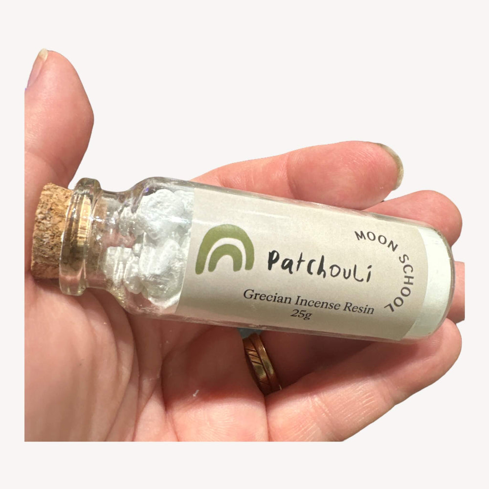 Bottle of Grecian Patchouli Incense Resin held in hand. Immerse yourself in the warm and earthy notes of Patchouli, a versatile and soothing resin crafted in Greece. Perfect for grounding practices, meditation, and moments of relaxation, especially during the potent energy of the Full Moon.