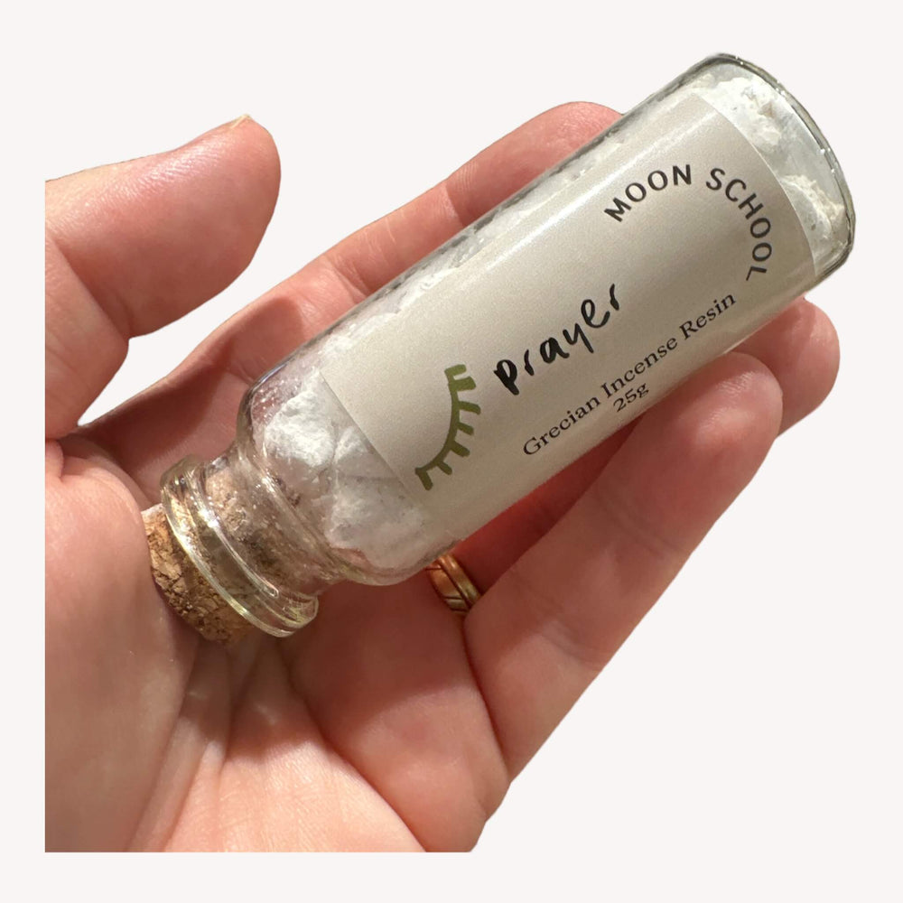 Bottle of 'Prayer' Incense Resin held in hand. Immerse yourself in the spiritually charged ambiance crafted in Greece. An ideal ally for meditation and contemplation, this resin sets the stage for source connection. Light a small piece on a heat-resistant surface for a fragrant journey.