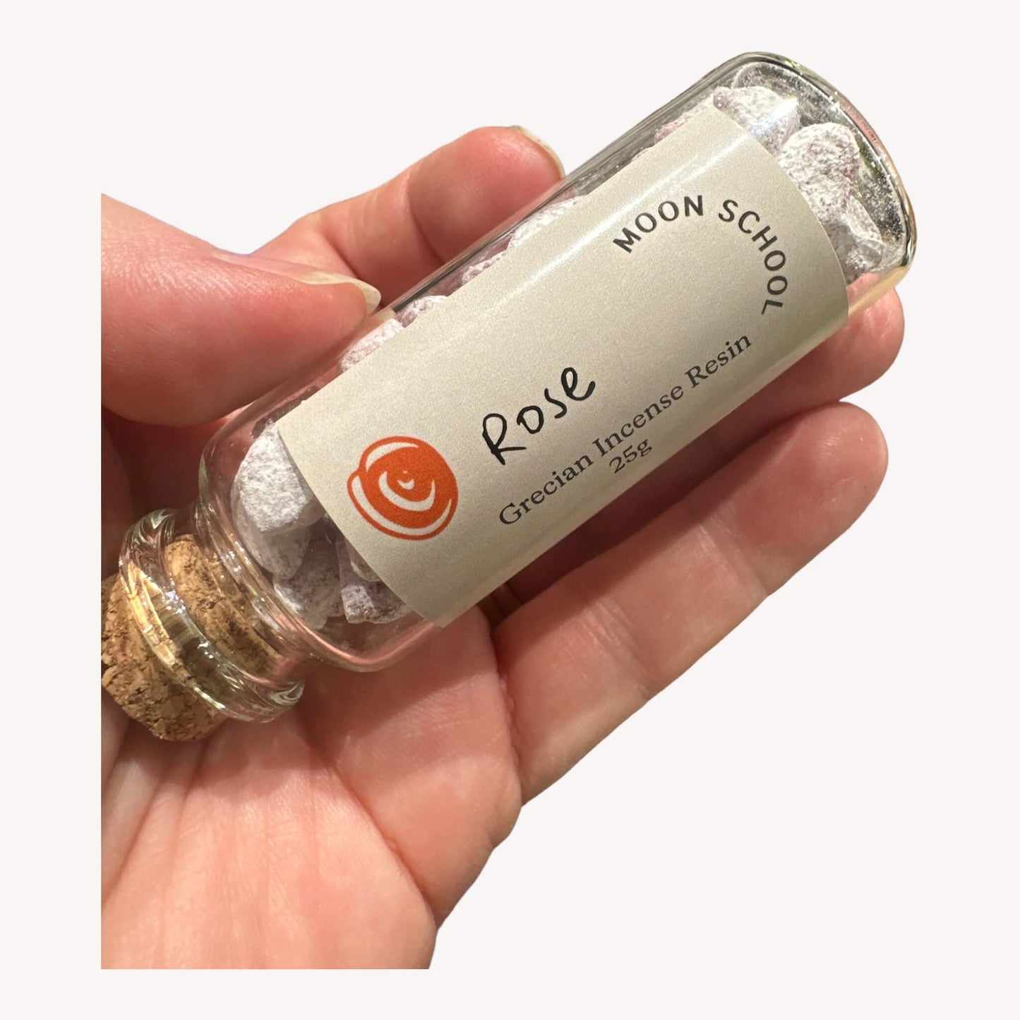 Bottle of 'Rose' Incense Resin delicately held in hand. Elevate your space with the gentle yet potent aroma of rose. Ideal for meditation, mindfulness, and heart-centered practices. Envelop your surroundings in the subtle, floral notes, creating an ambiance of grace and sophistication.