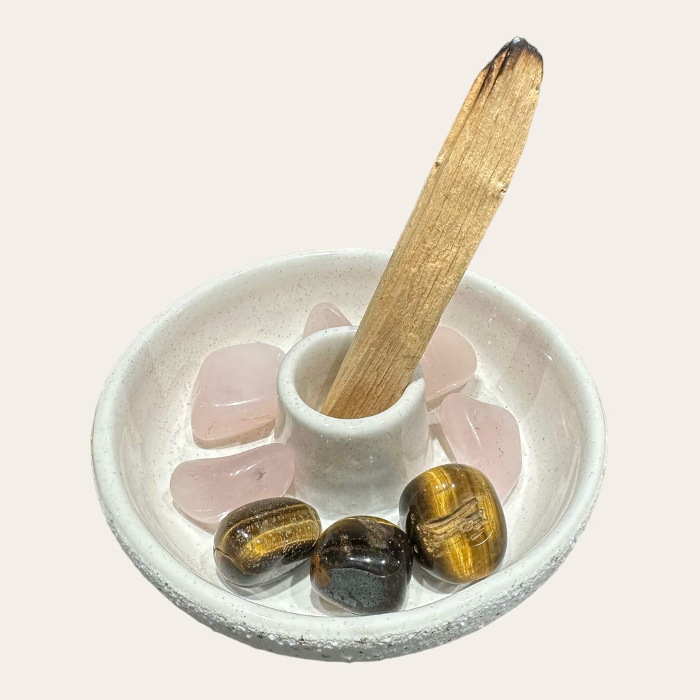 Alt text for the image showing the example with Palo Santo and crystal: The white speckled ceramic dish holds a Palo Santo stick upright, with a crystal placed beside it. The dish, measuring 11cm in diameter and 3.7cm in height, captures any ash.