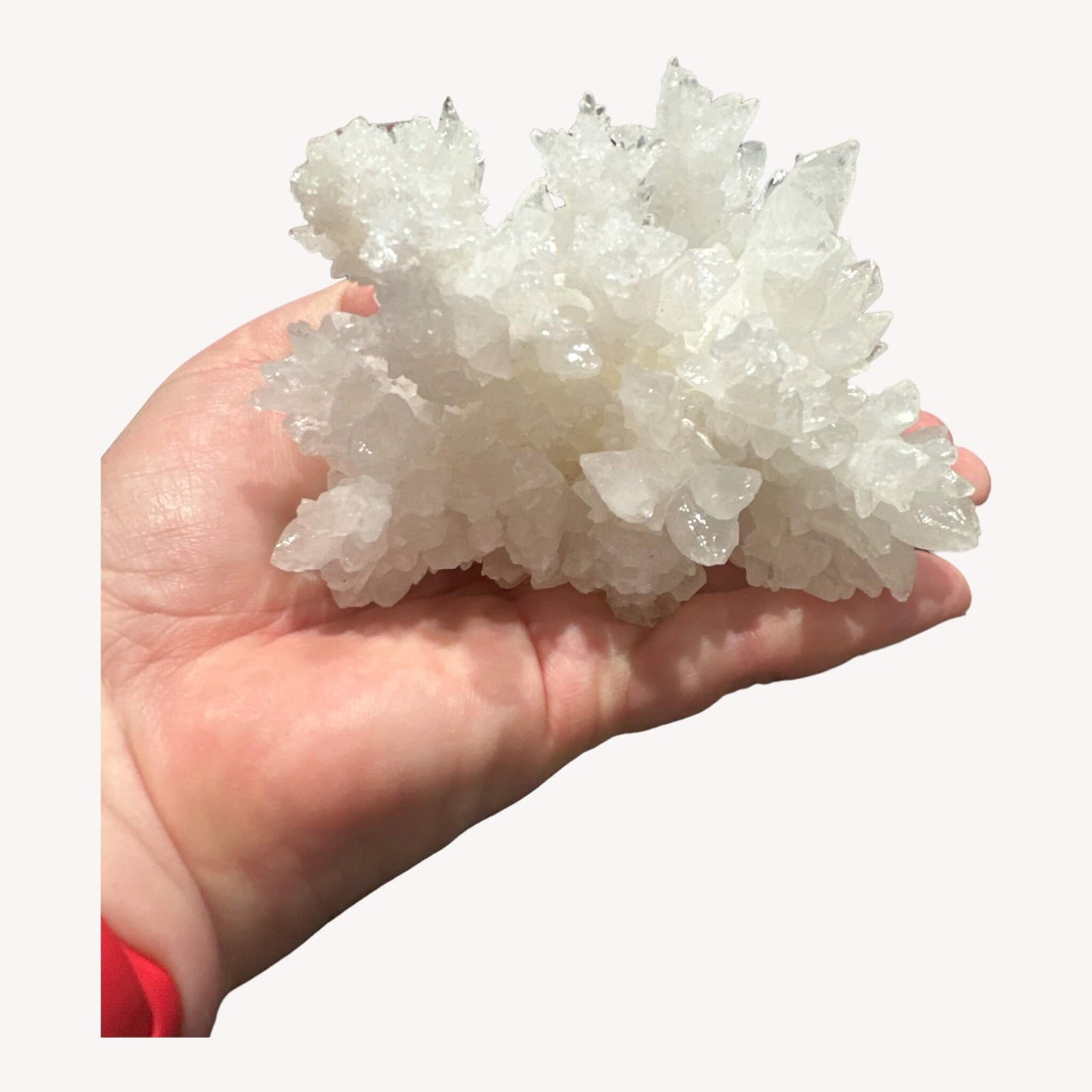 
                  
                    White Aragonite crystal cluster show on a hand
                  
                