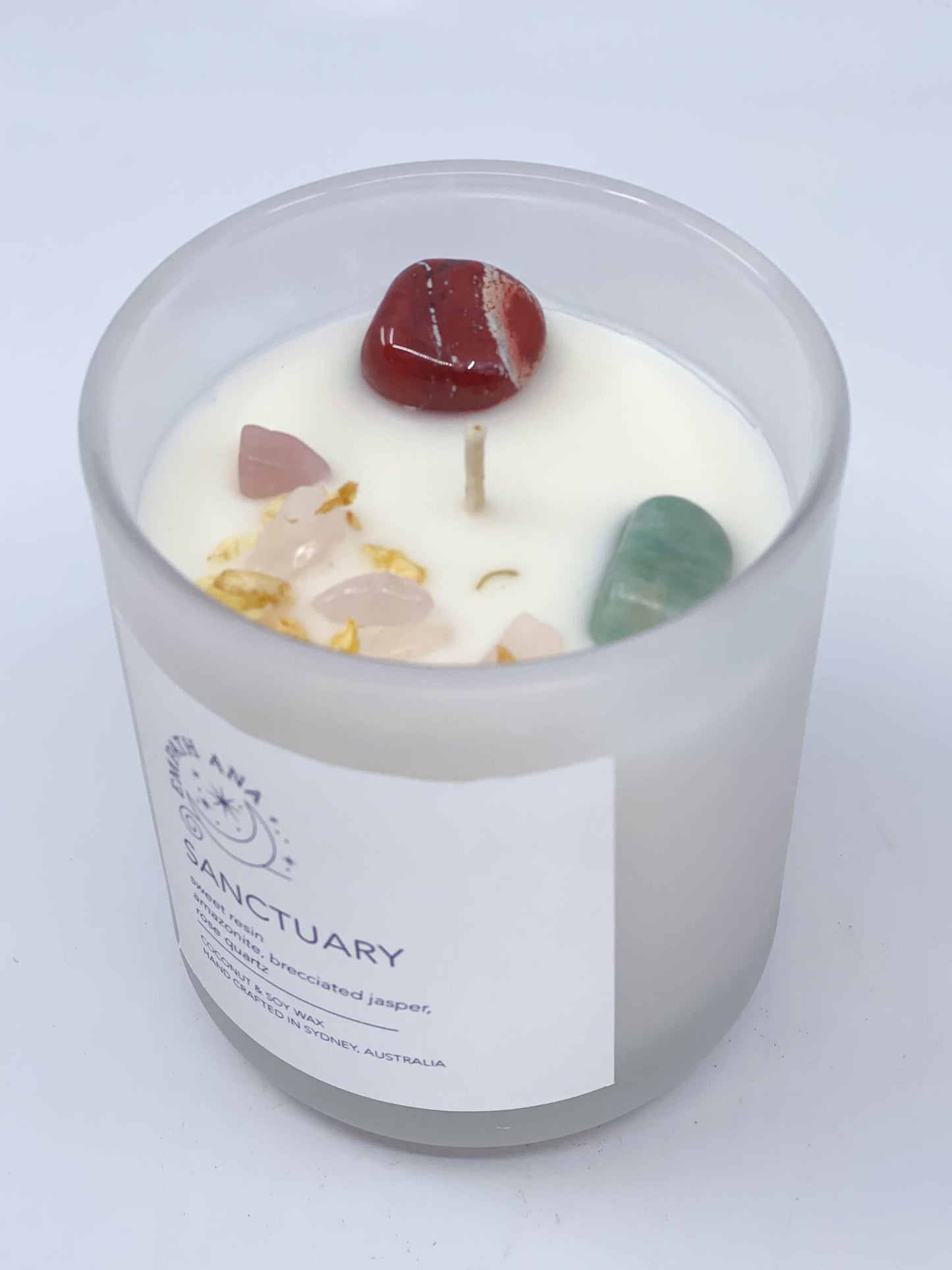 
                  
                    Top of Medium Sanctuary Crystal Candle: View from above, showcasing the harmonious trio of Amazonite, Brecciated-Jasper, and Rose Quartz crystals embedded in the coconut/soy wax. Medium size (200mls).
                  
                